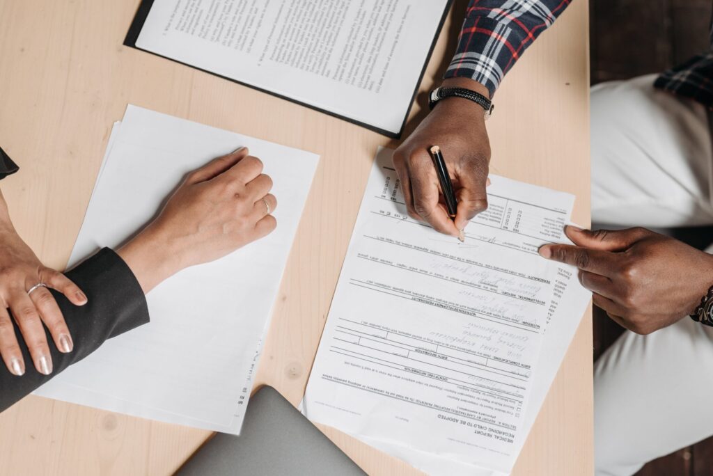 Two people reviewing and signing property documents